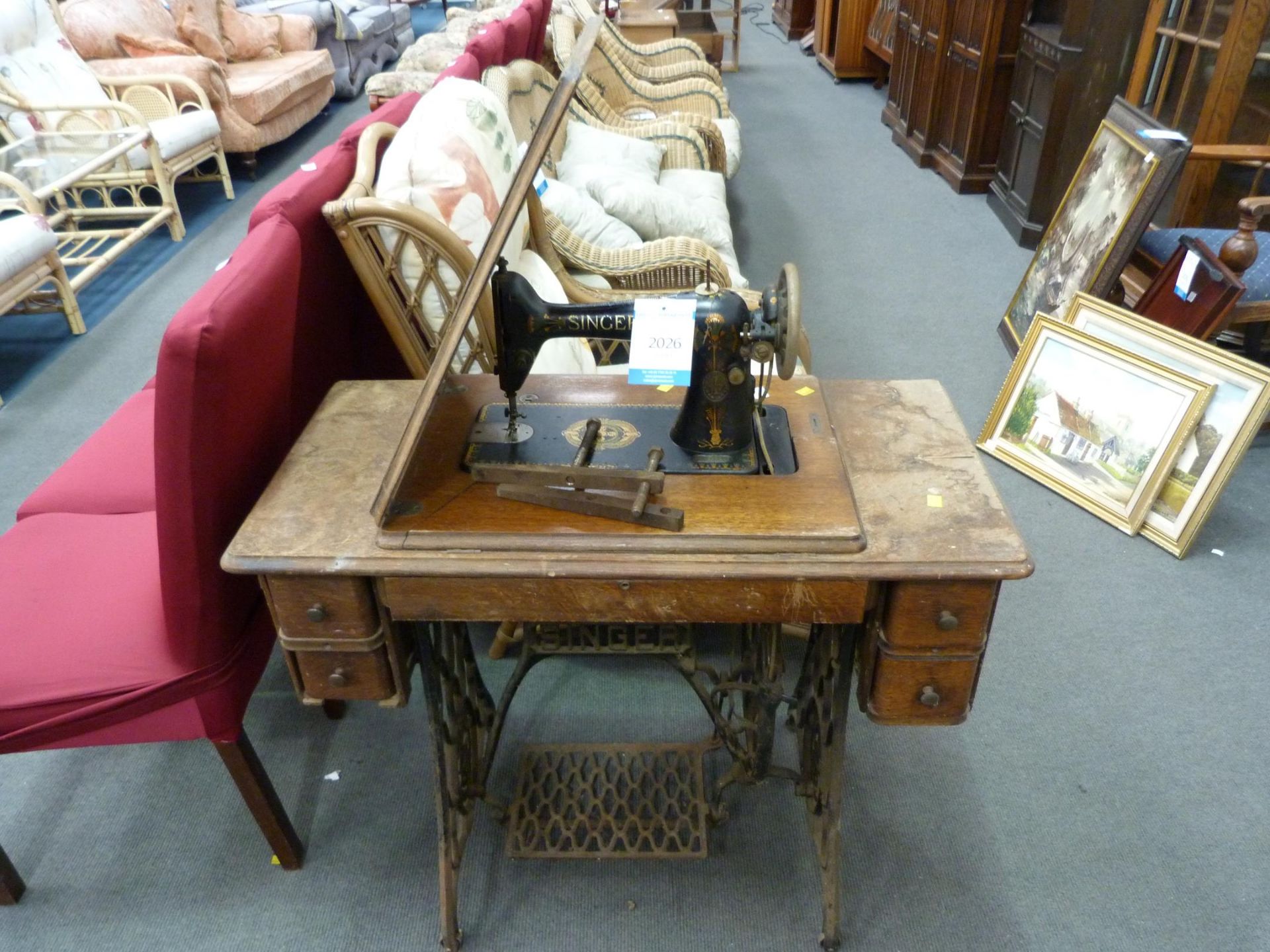 An early Treadle Singer Sewing Machine with fold down top and side, with four pullout drawers (