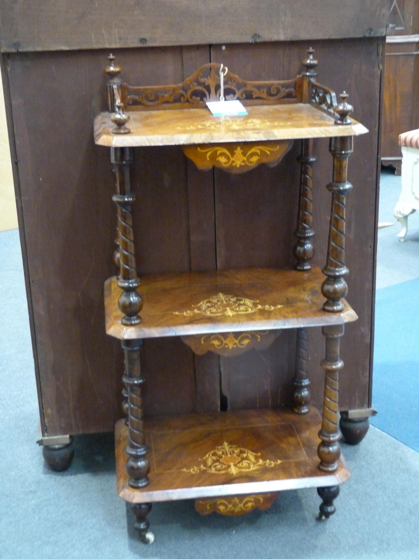 A Victorian inlaid three tiered walnut Whatnot, the lower tier being raised on turned legs and