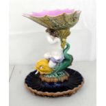 A 19th century Majolica Tazza, the shell shaped bowl supported on a cherub and dolphin column (A/