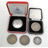 A 1909 half crown, a silver proof five pound coin, a 1935 and 1937 crown and a silver proficiency