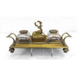 A Regency brass double ink desk stand with central covered box surmounting a stag, 32 by 19cm.