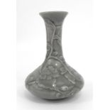 A celadon glazed vase decorated in slight relief with scrolling flowers 14cm high