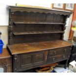 An oak dresser, with two shelf plate rack above two long drawers and a cupboard, on turned legs