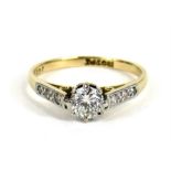 An 18ct gold diamond solitaire ring, the central diamond flanked by six diamonds