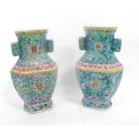 A pair of Chinese vases, decorated flowers in enamal colours on a turquoise ground 26cm high