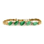 A yellow metal jade and diamond bracelet set with five oval jade cabouchons and eight diamonds.