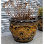 A large terracotta garden planter, decorated a pair of dragons 65cm diameter