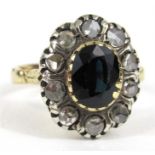 A yellow metal diamond and sapphire ring , the central oval sapphire surrounded by ten diamonds (