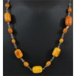 An early 20th century butterscotch amber necklace on a rolled gold chain.