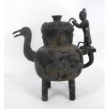 A Chinese bronze teapot with figural handle and duck spout standing on four legs 37cm high