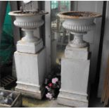 A pair of Victorian cast iron Campana garden urns on stands 120cm high 52cm diameter