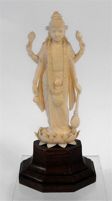 An early 20th century Indian ivory carving depicting a multi armed deity standing on a lotus flower,