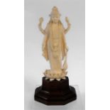 An early 20th century Indian ivory carving depicting a multi armed deity standing on a lotus flower,