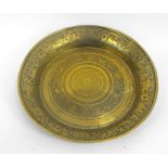 An Indian brass dish, decorated animals and foliate scrolls with script to the inner rim 37cm