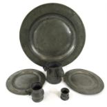 A large pewter charger 42cm diameter two similar smaller, 24cm diameter and three pewter tankards (