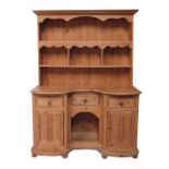 A Victorian style dog kennel dresser, the shelved plate rack above three short drawers and two