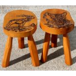 A pair of Scandinavian wooden stools with poker work decoration, one with a fox and one with a deer,