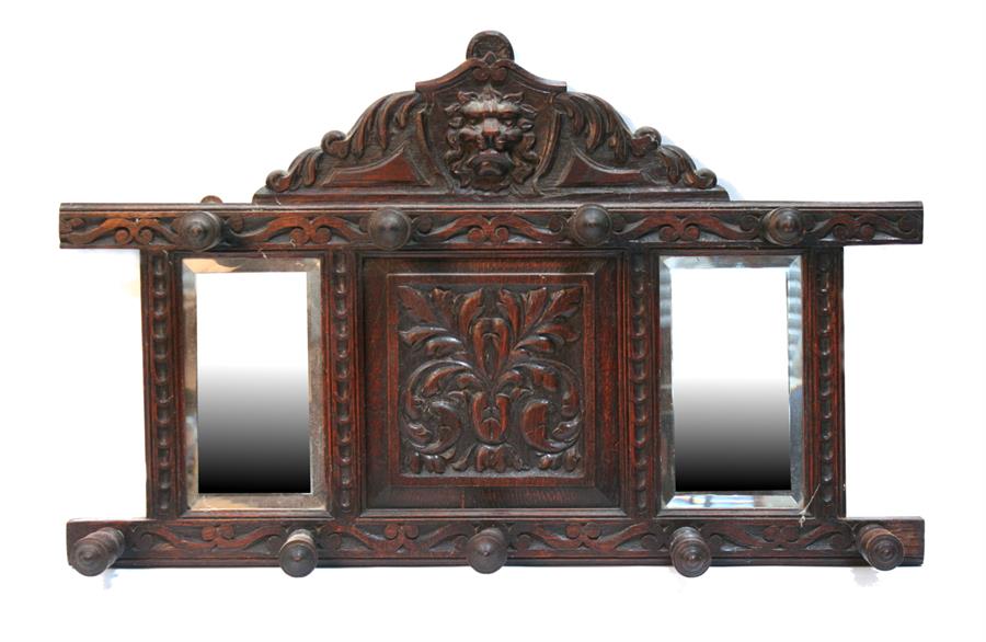 A Victorian oak wall mounted hat & coat rack, with central carved panel flanked by a pair of mirrors