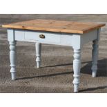 A painted pine kitchen table with central drawer, on turned legs, 92 by 117cms wide.