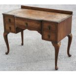 A figured walnut desk with central frieze drawer flanked by four short drawers, on cabriole legs,