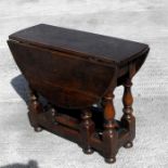 An 18th century style oak gateleg table with turned legs, of small proportions, 60cms wide.