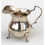 A silver cream jug, dated Birmingham 1902, with coin inset to base, 8cm high.