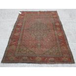 A Persian rug, with central gul within foliate border 125cm x 195cm