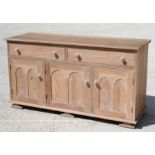 A limed oak sideboard with two long drawers above three panelled doors, 144cm wide.