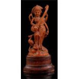 An Indian carved sandalwood figure depicting a multi-armed deity playing a musical instrument,