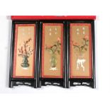 Three Chinese hardstone and pink coral panels each depicting flowers in vases 14cm x 34cm