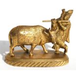 An Indian gilded bronze group of a buffalo and a figure playing a flute, 7.5cm high.