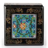 An early 20th century Chinese lacquer box with inset cloisonne panel decorated with flowers on a
