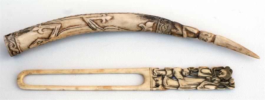 A Chinese ivory paper knife with carved handle, 22cm long; and a Balinese antler tip carved with a