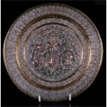 An Indian brass and copper repousse plaque decorated with three deities, 23.5cm diameter.