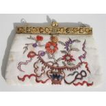 A Chinese embroidered evening bag with gilded white metal mounts set with coral & turquoise 18cm x