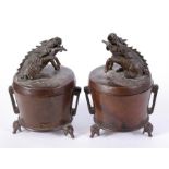 A pair of Chinese two-handled bronze censers with kylin finials, standing on three elephant head