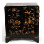 A late 19th century Japanese lacquered table cabinet decorated with gilded flower and birds on a