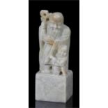 A Chinese figural soapstone desk seal, 11.5cm high.