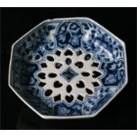 An 18th century Delft blue & white octagonal strainer, decorated with flowers, 13cm diameter.