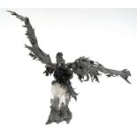 A 20thcentury modern metal and crystal sculpture, depicting an eagle on a tree stump with outswept
