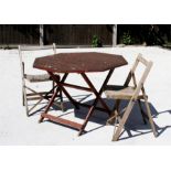 An octagonal folding teak garden table, 100cm diameter, and two folding garden chairs (3).