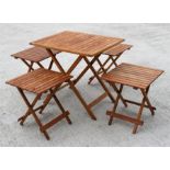 A teak folding garden table and four smaller matching tables or stools (5).