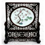 A Chinese porcelain table screen, the oval panel painted with swallows on a knarled blossoming