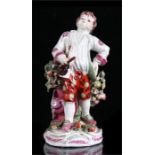 An 18th century Bow porcelain figure depicting a young boy holding a ladle, iron red anchor & dagger