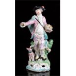 A 19th century porcelain figure (possibly Bow), depicting a young man holding a basket of fruit with