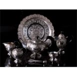 A Malaysian seven piece silver tea set, highly decorated with foliate scrolls and province crests,