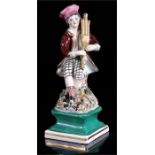 An early 19th century Staffordshire hollow based figure of a man sat on a tree stump playing the