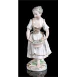 A 19th century porcelain figure of a young girl holding a basket of flowers, 17cm high.