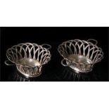 A pair of George II silver two handled lattice work baskets each with central engraved armorial,