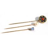 A yellow metal enamel & coral stick pin; a pearl mounted stick pin; and a pale blue blue stone